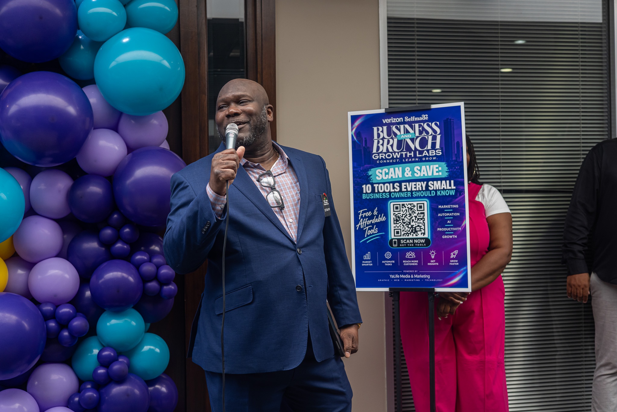 Speaker addressing attendees beside the Business Brunch & Growth Labs event display on September 19, 2026